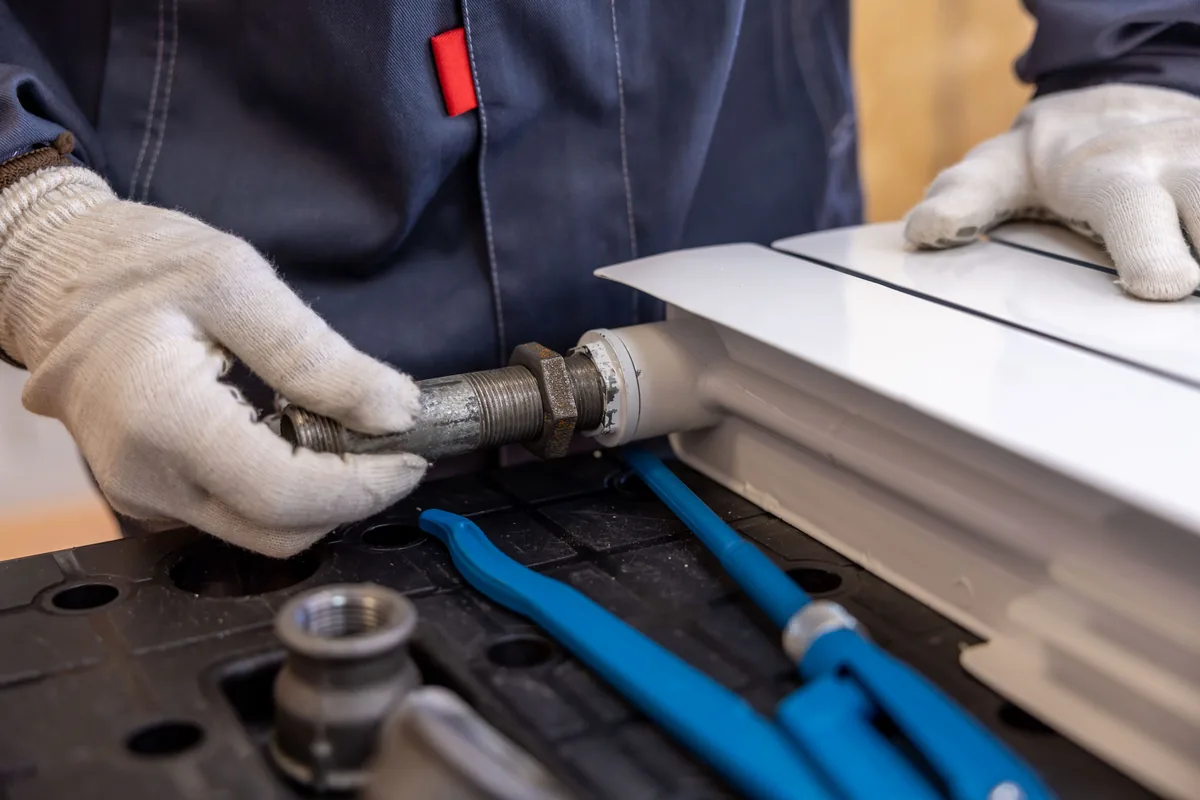Technician connecting pipework to heating equipment